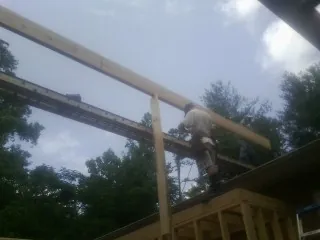 Carpenter setting a ridge beam over a new addition frame — Ice Dam Removal by Roofing Brothers in Rewey