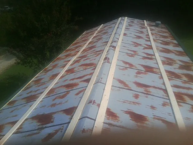 Rusted metal roof panels with new wood purlins before replacement — Storm Damage Roof Repair in Rewey by Roofing Brothers