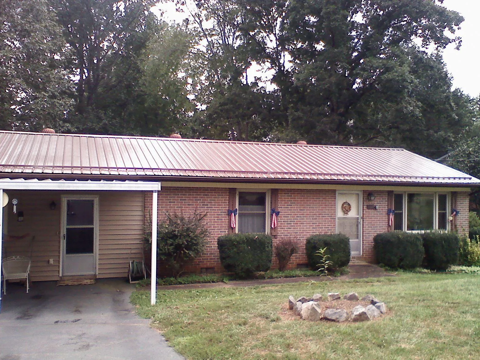 Bronze metal roof and carport on a brick ranch home — Roof Repair work by our crew in Rewey